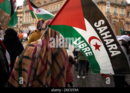A woman holds a Sahrawi flag reading 'Free Sahara'. Sahrawi people of Toulouse gathered against the recognition by Israel of the sovereignty of the Marocco Kingdom on the Western Sahara and its inhabitants, the Sahrawis in exchange of a normalization of relations between Israel and Marocco (accord powered by acting U.S. president Trump). The disputed territory must hold an independence referendum with UN help since 1973. In 1975, The Polisario Front declared the independence of the Sahrawi Arab Democratic Republic. Toulouse. France. December 19th 2020. (Photo by Alain Pitton/NurPhoto) Stock Photo