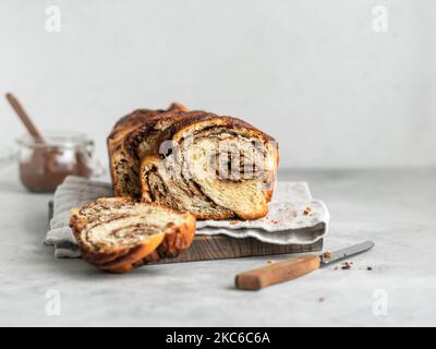 Chocolate yeast cake babka, swirl marbled brioche with chocolate on gray background with text space Stock Photo