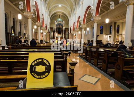 A sign reading 'Please Wear A Face Mask' seen inside Whitefriar Street Church, in Dublin city center. On Wednesday, December 23, 2020, in Dublin, Ireland. (Photo by Artur Widak/NurPhoto) Stock Photo