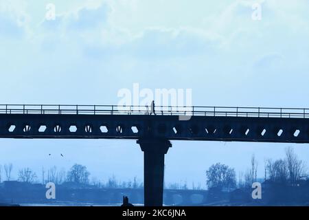 A woman walks on a bridge over river Jehlum on a Cold day in Baramulla Jammu and Kashmir India on 29 December 2020 (Photo by Nasir Kachroo/NurPhoto) Stock Photo