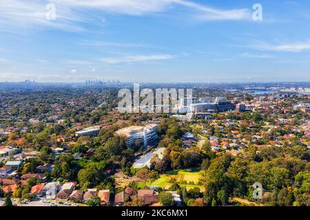 Local green residential suburbs in Sydney West - aerial cityscape towards distant city CBD skyline. Stock Photo