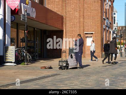 Busker on a deserted high street in Uttoxeter, Staffordshire, UK Stock Photo