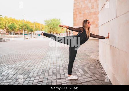 Slim woman doing yoga on street Stock Photo