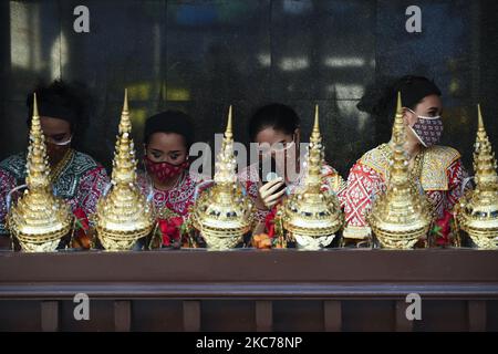 Thai dancers wearing protective masks use their mobile phones while waiting for worshippers at Erawan shrine, popular with tourists, in Bangkok, Thailand, 10 January 2021. (Photo by Anusak Laowilas/NurPhoto) Stock Photo