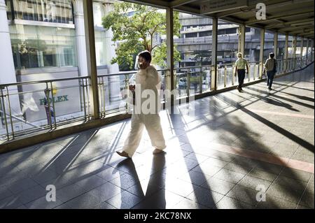 A woman wearing a hazmat suit walks a past skywalk amid a new wave of Covid-19 infections in Bangkok, Thailand, 10 January 2021. (Photo by Anusak Laowilas/NurPhoto) Stock Photo