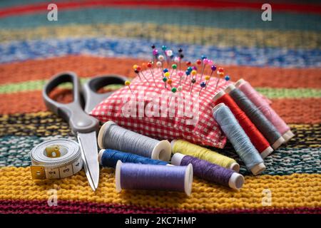 Sewing tools and accessories, spools of thread, scissor, pins and tape measure, selective focus Stock Photo