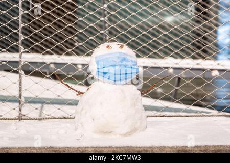 A COVID-19 compliant snowman with a medical facemask as seen in the night after the first snowfall of the year in Eindhoven city center in the Netherlands on 16 January 2021. (Photo by Nicolas Economou/NurPhoto) Stock Photo