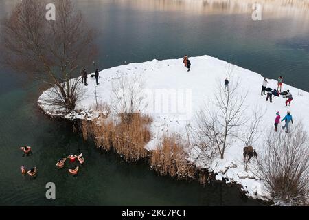 An aerial view on winter swimmers dipping in cold water of Zakrzowek lake, a former limestone quarry located close to the city center in Krakow, Poland on January 17, 2021. Restrictions in Poland introduced due to the coronavirus pandemic have resulted in the ongoing closure of public swimming pools, gyms and other sports centers. Fans of physical activities who want to strengthen their body and immune system are more and more willing to take a winter bath in natural cold water reservoirs. Winter swimming has become extremely popular among Polish people of all ages. (Photo by Beata Zawrzel/Nur Stock Photo