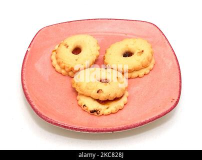 Danish butter sweet cookies with jam inside on pink plate isolated on white Stock Photo