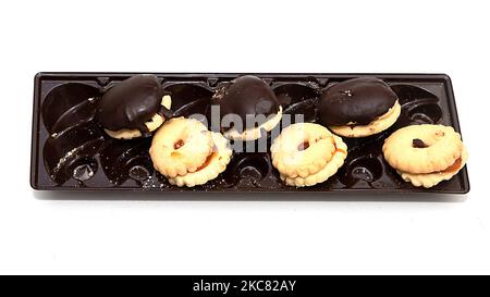 Sweet chocolate cookies with butter ones on plastic tray isolated on white background Stock Photo