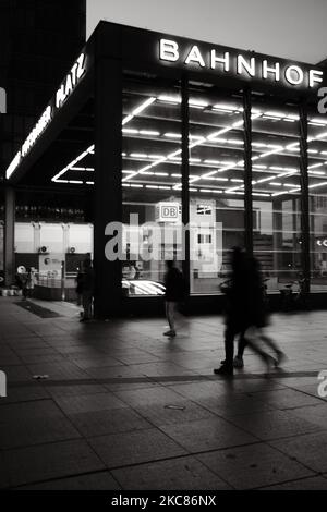 A vertical shot of the entrance to Potsdamer Platz train station with people walking by at night Stock Photo