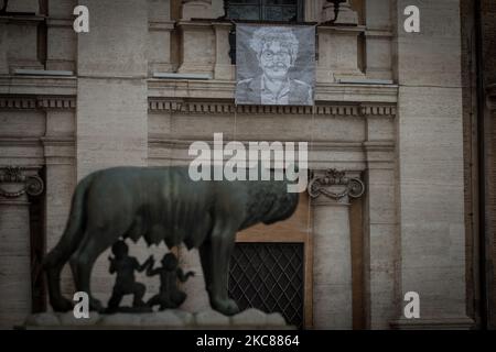 A portrait of the Egyptian student and activist Patrick Zaki, detained in Cairo since February 2020, hangs on from the facade of Palazzo Nuovo in Piazza del Campidoglio, seat of Rome's town hall, as the Capitoline She-wolf is seen at bottom, in Rome, Italy, on January 25, 2021. (Photo by Andrea Ronchini/NurPhoto) Stock Photo