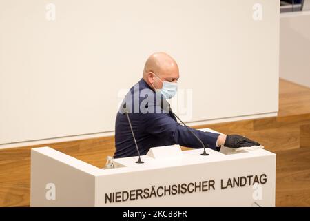 Between speakers, the lectern is disinfected during the first regular session of the Lower Saxony Parliament in 2021 on 27 January 2021 in Hanover. (Photo by Peter Niedung/NurPhoto) Stock Photo