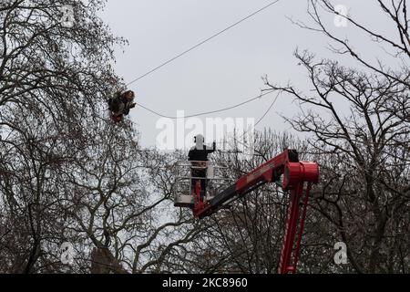 An environmental protester hangs on a zip wire as an officer stands on a cherry picker, during a police operation to clear the site of a ‘Stop HS2’ camp at Euston Square Gardens, on 27 January, 2021 in London, England. Despite the evictions, a small group of activists remain inside a tunnel, which was secretly constructed under the site to try to prevent the next phase of work on the high speed rail project set to link London with Birmingham, Manchester and Leeds. (Photo by WIktor Szymanowicz/NurPhoto) Stock Photo
