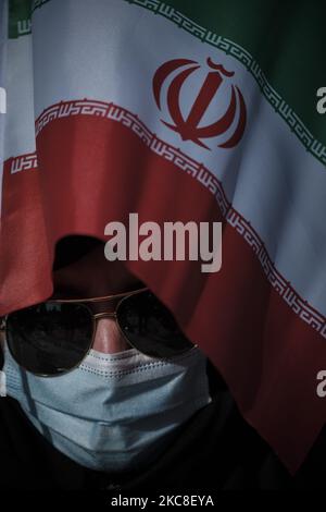 Pro Mask Sign March A woman holds an Iranian flag as part of a pro-government campaign in ...