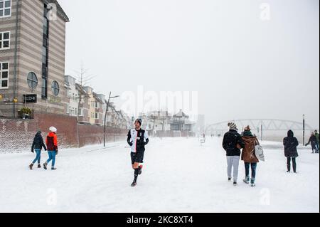 A man is running on the snow during the snowstorm called Darcy, in Nijmegen, on February 7th, 2021. (Photo by Romy Arroyo Fernandez/NurPhoto) Stock Photo