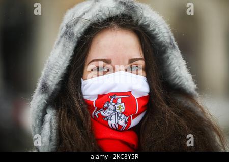 A young woman wears a face mask with Belarusian flag during a demonstration on the Day of Solidarity with Belarus at the Main Square in Krakow, Poland on February 7, 2021. Opposition leader Svyatlana Tsikhanouskaya has called on all non-indifferent people to support Belarusian protesters by joining the Day of Solidarity with Belarus February, 7. On that day supporters can show solidarity by participating in events and rallies, displaying national Belarusian white-red-white colours, writing letters to Belarusian political prisoners, making posts bearing the hashtag #StandWithBelarus on social m Stock Photo