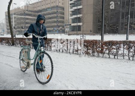 People as seen carrying their bicycles because of the difficulty of riding on the snow. Blizzard from the snowstorm Darcy in the Netherlands, the first heavy snowfall with intense strong winds after 2010 disrupting transport all over the country. Dutch people woke up on Sunday with a layer of snow covering everything. Many accidents occurred on the roads due to the storm and the icy condition, while there was problem with trains as well. In the city of Eindhoven in North Brabant, rail and buses services ceased operation, the airport followed and air traffic was diverted. People went outside in Stock Photo