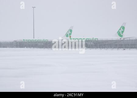 Snowstorm shuts down the airport of Eindhoven EIN in the Netherlands. Heavy snow fall disrupts the air traffic that caused diversions to Germany on Sunday. Blizzard from storm Darcy hit the country since Sunday morning (07.02.2021) resulting problems in public transportation. In the snow-covered Eindhoven airport, Transavia airplanes are seen grounded while heavy machinery is cleaning the taxiway and runway. Dozens of flights that were due to depart were delayed or canceled at Schiphol Airport in Amsterdam due to the arctic cold winter weather, the icy and freezing subzero temperature conditio Stock Photo