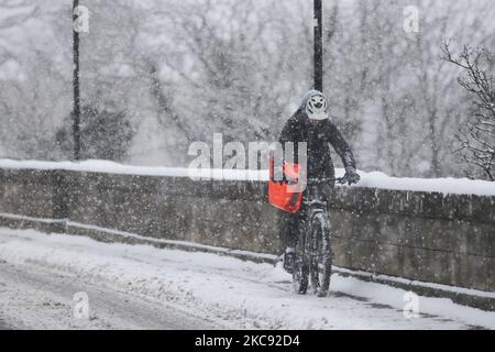 A member of the public cycles through the snow on February 10, 2021 in Kelso, Scotland. Storm Darcy has caused many Yellow warnings for snow cover over much of England and Scotland, as well as parts of Northern Ireland until Wednesday with temperatures as low as -15C being forecast for parts of Scotland. (Photo by Ewan Bootman/NurPhoto) Stock Photo