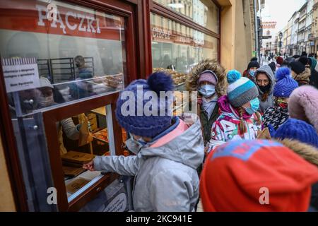 People queue to buy donuts at bakery 'Dobra Paczkarnia' on Fat Thursday. Krakow, Poland on Fenruary 11, 2021. Fat Thursday is a traditional Catholic Christian feast on the last Thursday before Lent. It symbolizes the celebration of Carnival. The most popular dish served on that day in Poland are 'paczki' - fist-sized donuts filled with marmalade. (Photo by Beata Zawrzel/NurPhoto) Stock Photo