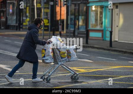 A young man wearing a face mask seen pushing a shopping cart in Ranelagh, Dublin, during Level 5 Covid-19 lockdown. On Sunday, February 14, 2021, in Ranelagh, Dublin, Ireland. (Photo by Artur Widak/NurPhoto) Stock Photo