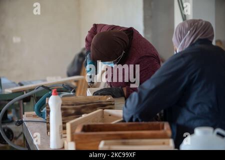 Palestinian women work at their carpentry shop in Al-Walajah village near the West Bank city of Bethlehem, on Feb. 14, 2021. Five years ago seven Palestinian housewives started their own project on wood recycling to make a living, turning waste timber into usable products, which were sold to souvenir shops and on social media. (Photo by Luay Sababa/NurPhoto) Stock Photo