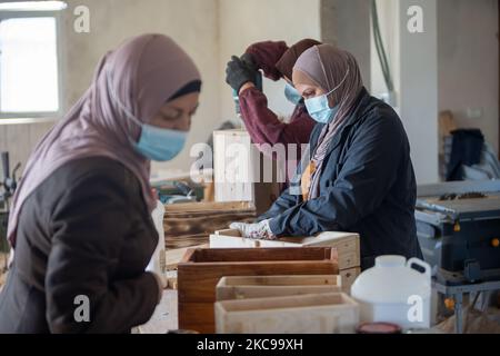 Palestinian women work at their carpentry shop in Al-Walajah village near the West Bank city of Bethlehem, on Feb. 14, 2021. Five years ago seven Palestinian housewives started their own project on wood recycling to make a living, turning waste timber into usable products, which were sold to souvenir shops and on social media. (Photo by Luay Sababa/NurPhoto) Stock Photo