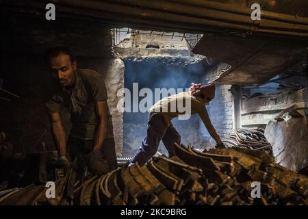 Bangladeshi rolling mill worker seen working in the steel re-rolling mill without proper safety gear or tools in Postagola, Bangladesh on February 15, 2021. In these mills iron is forged in 1200 + to 1300+ Celsius. In such a heated place the soles of their shoes are likely to be burnt off with one careless step. (Photo by Ahmed Salahuddin/NurPhoto) Stock Photo