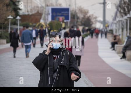 An Iranian woman speaks on her smartphone while standing near a bridge that is equipped with a Huawei 5G modem in the Water and Fire park in northern Tehran on February 16, 2021. Iran’s first 5G network has ran by the Irancell company which is an Iranian telecommunications company that operates Iran's largest 2G-3G-4G-4.5G also 5G mobile network, and fixed wireless TD-LTE internet services. (Photo by Morteza Nikoubazl/NurPhoto) Stock Photo