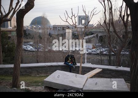 An Iranian man uses his smartphone as he sits in the Water and Fire park in northern Tehran on February 16, 2021. Iran’s first 5G network has ran by the Irancell company which is an Iranian telecommunications company that operates Iran's largest 2G-3G-4G-4.5G also 5G mobile network, and fixed wireless TD-LTE internet services. (Photo by Morteza Nikoubazl/NurPhoto) Stock Photo