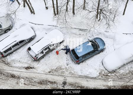 A man plows snow at his car after a heavy snowfall in St. Petersburg, Russia on February 22, 2021 (Photo by Valya Egorshin/NurPhoto) Stock Photo