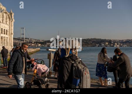 A man carries his dog on his shoulders in the Ortakoy district of Istanbul, Turkey seen on February 26, 2021. As part of the measures against the spreading of COVID-19, restaurants and cafes only provide take-away and delivery services, and people prefer socializing at the seasides or parks. Turkey will start to gradually normalize from coronavirus restrictions as of March 1, said Health Minister Fahrettin Koca. (Photo by Erhan Demirtas/NurPhoto) Stock Photo