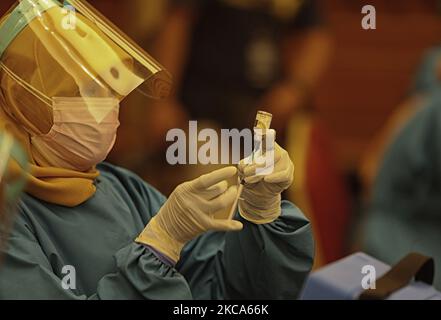 A health worker prepares to administer the Covid-19 coronavirus vaccine during a mass vaccination public servants and front-line workers in Bogor City, Indonesia, on March 1, 2021. (Photo by Adriana Adie/NurPhoto) Stock Photo