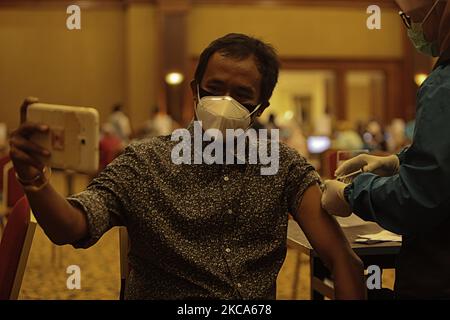 A man takes a selfie picture as he receives the Covid-19 coronavirus vaccine during a mass vaccination public servants and front-line workers in Bogor City, Indonesia, on March 1, 2021. (Photo by Adriana Adie/NurPhoto) Stock Photo