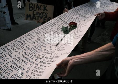 Protesters hold a long scroll which bears the names of the hundreds of Minnesotans killed by police over decades, on March 7, 2021. One day before the jury selection process for Derek Chauvin’s trial began, dozens of activist and faith organizations were joined by hundreds of Black Lives Matter protesters in downtown Minneapolis to demand justice for George Floyd. After holding a rally outside the heavily fortified Hennepin County Government Center—the location of the trial—protesters participated in a silent march through downtown. A group of community members carried a symbolic casket at the Stock Photo