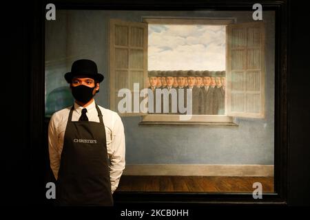 A member of staff poses with oil on canvas work 'Le mois des vendanges', by Rene Magritte, estimated at GBP10,000,000-15,000,000, during a press preview for the upcoming 20th Century Art and Art of the Surreal sale at Christie's auction house in London, England, on March 16, 2021. The sale takes place next Tuesday, March 23. (Photo by David Cliff/NurPhoto) Stock Photo