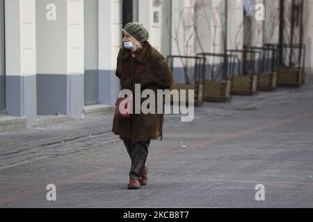 An elderly woman wearing a face mask is seen walking past closed shops in Warsaw, Poland on March 20, 2020. The Polish health ministry imposed a country wide lockdown starting Saturday following a surge in new cases of coronavirus infections. Poland has seen its cases rise sharply and briefly hit the top 5 worldwide in absolute number of deaths. Hotels, shopping malls, cinemas, cultural institutions and non-essential services will be closed until April 9. (Photo by Jaap Arriens/NurPhoto) Stock Photo