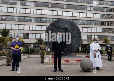 LONDON, UNITED KINGDOM - MARCH 23, 2021: NHS England Chief Executive Sir Simon Stevens (C) observes a national minute of silence outside St. Thomas's hospital in central London to remember those who have died from the Coronavirus as part of the National Day of Reflection held one year since British Prime Minister Boris Johnson announced the country was going into first lockdown to stop the spread of Covid-19, on 23 March, 2021 in London, England. Since then the UK has suffered the worst Covid-19 death-toll in Europe with more than 126,000 lives lost and the economy experienced the biggest down Stock Photo