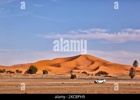 Vehicle travels through the Erg Chebbi desert near the small village of Merzouga in Morocco, Africa. Merzouga is a village in the Sahara Desert in Morocco, on the edge of Erg Chebbi, a 50km long and 5km wide set of sand dunes that reach up to 350m. (Photo by Creative Touch Imaging Ltd./NurPhoto) Stock Photo