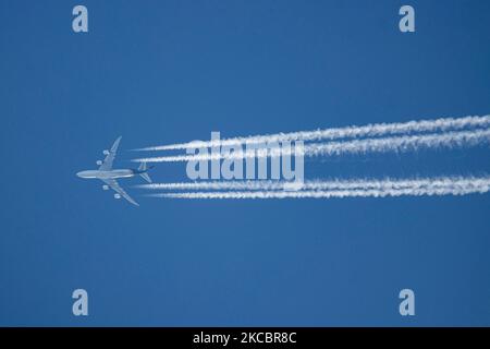 A UPS Boeing 747-8F aircraft as seen flying in the blue sky over the Netherlands. The overflying Jumbo Jet airplane is cruising at high altitude leaving condensation stripes, vapour lines behind known as contrails from the 4 jet engines is a freight edition of the iconic Queen of the Skies, the Boeing 747. The plane is flying from Louisville SDF, the airline's base and shipping hub to Cologne CGN in Germany. UPS Airlines, a cargo airline is part of UPS United Parcel Service is an American multinational package delivery and supply chain management company. During the Covid-19 Coronavirus pandem Stock Photo
