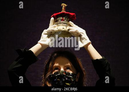 A member of staff poses holding an Edwardian silver-gilt duchess's coronet, estimated at GBP1,000-1,500, during a press preview for the upcoming sale of items from Scotland's Dunrobin Castle, under instruction from the 25th Earl of Sutherland, at Bonhams auction house in London, England, on March 30, 2021. The sale itself takes place on April 20 in Edinburgh. (Photo by David Cliff/NurPhoto) Stock Photo