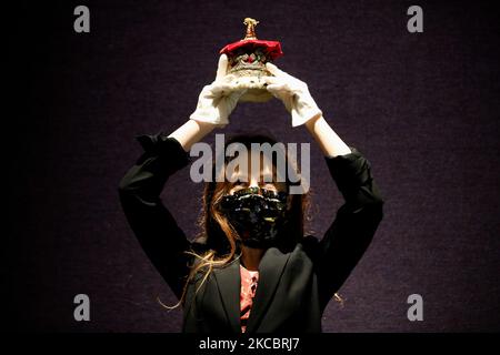 A member of staff poses holding an Edwardian silver-gilt duchess's coronet, estimated at GBP1,000-1,500, during a press preview for the upcoming sale of items from Scotland's Dunrobin Castle, under instruction from the 25th Earl of Sutherland, at Bonhams auction house in London, England, on March 30, 2021. The sale itself takes place on April 20 in Edinburgh. (Photo by David Cliff/NurPhoto) Stock Photo