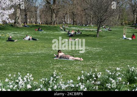 LONDON, UNITED KINGDOM - MARCH 30, 2021: People enjoy exceptionally warm and sunny weather in St James's Park, making the most of eased Coronavirus restrictions, on 30 March, 2021 in London, England. Temperatures in London are expected to reach 24C over two days caused by a mini-heatwave from the continent. (Photo by WIktor Szymanowicz/NurPhoto) Stock Photo