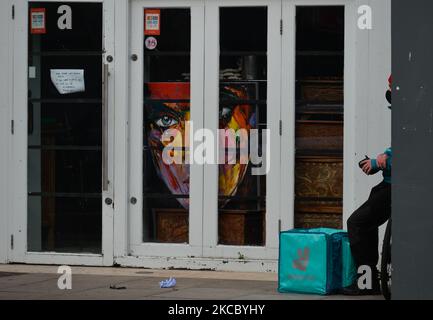 A Deliveroo currier awaiting for his order outside an Art Gallery in Dublin city center during Level 5 Covid-19 lockdown. On Thursday, April 1, 2021, in Dublin, Ireland. (Photo by Artur Widak/NurPhoto) Stock Photo