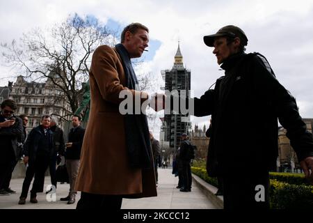 Reclaim Party leader and London mayoral candidate Laurence Fox smokes a cigarette and shakes hands with a homeless man after presenting his election manifesto at the statue of Winston Churchill in Parliament Square in London, England, on April 7, 2021. The Mayor of London will be voted for next month, on May 6, in tandem with elections for the London Assembly and other local elections across England, postponed from 2020 due to the coronavirus pandemic. Incumbent Mayor Sadiq Khan of the Labour Party is running for a second term, with his principal rival the Conservative Party candidate Shaun Ba Stock Photo