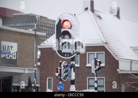 Snow on a traffic light in Eindhoven city. The third day of the unusual April snowfall in The Netherlands, the country wakes up snow covered after an intense morning snowfall, a bizarre event for April. The 3rd day of low temperatures and snowfall in the Netherlands after the 'White Easter' Monday with a significant drop of temperature, reaching freezing point according to Dutch meteorological agency KNMI making Easter Monday one of the coldest ever days with low temperatures recorded. Additional to the snow, hail and high speed strong ice-cold wind occurred. The KNMI has issued a code yellow  Stock Photo
