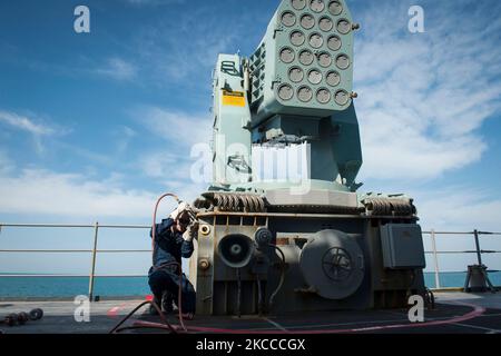 Seaman Apprentice performs maintenance on a rolling airframe missile launcher. Stock Photo