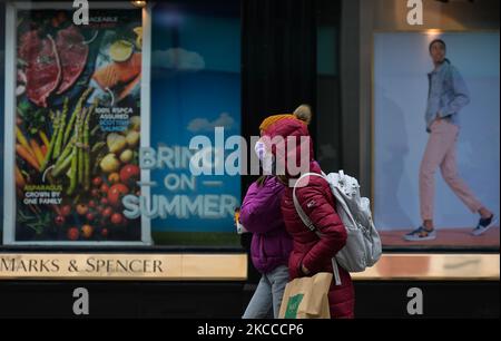 Two women walk past Marks and Spencer's window with a sticker that reads 'Bring On Summer' - on Grafton Street, Dublin city center, during Level 5 Covid-19 lockdown. On Wednesday, 7 April 2021, in Dublin, Ireland. (Photo by Artur Widak/NurPhoto) Stock Photo