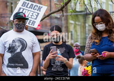 People look at their cell phones to update their social media as people gather at Washington Park in memorial and then march to where Timothy Thomas died 20 years ago this month after being shot and killed by Cincinnati Police officer, Stephen Roach, which eventually led to city-wide civil unrest, Wednesday, April 7, 2021, in Cincinnati, Ohio, United States. (Photo by Jason Whitman/NurPhoto) Stock Photo